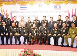 Military officials, led by Lt. Gen. Witsanu Sriyapan, director-general of Thai Border Military Affairs, and Gen. Bualiang Champaphan, deputy chief of staff for the Lao People’s Army (both seated, center) pose for a commemorative photo after the meeting.